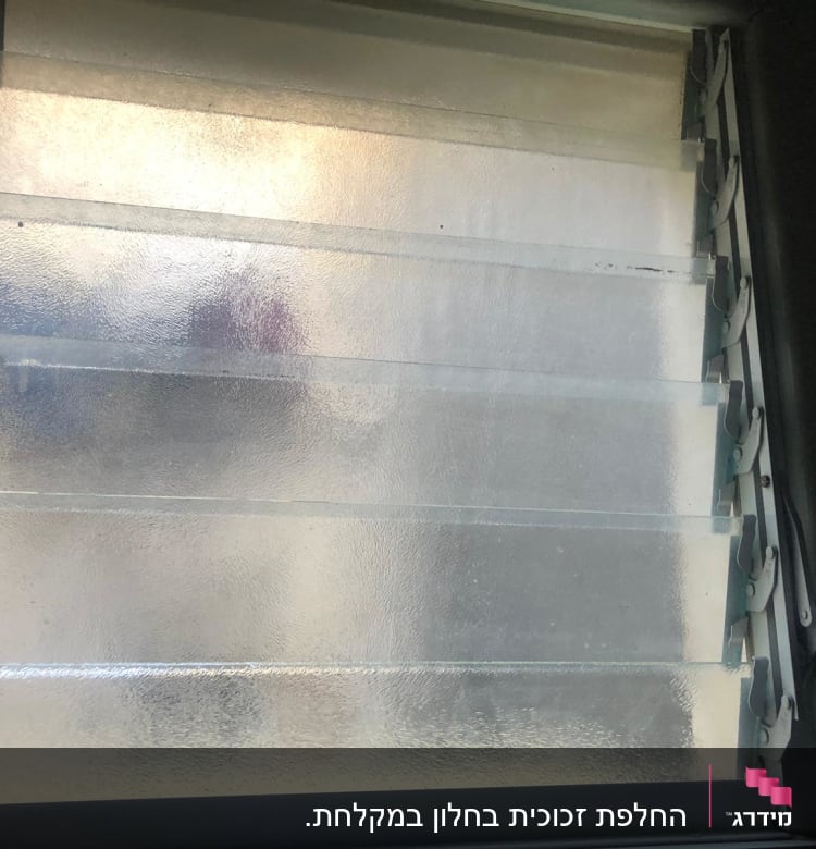 חלון זכוכית מט במקלחת עם תריסים פתוחים למחצה